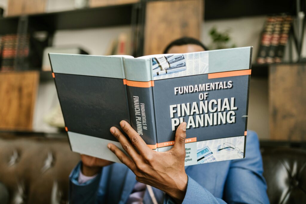 A Person Reading a Book About Fundamentals of Financial Planning