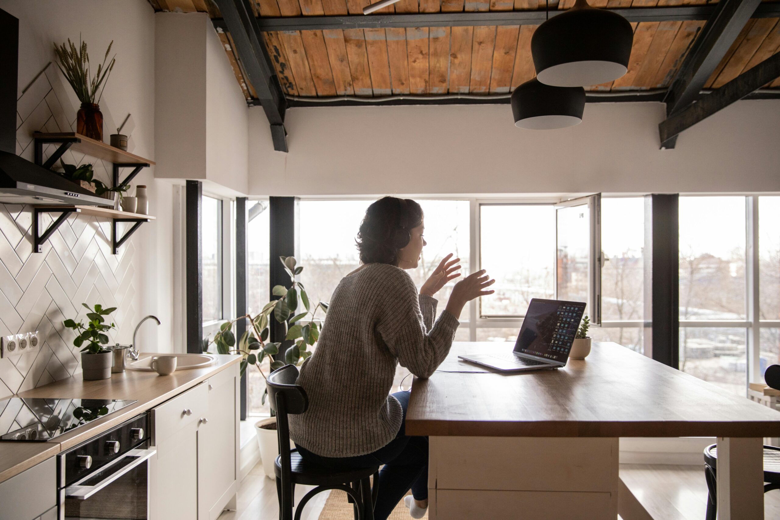 A freelancer woman attending an online meeting in her kitchen
